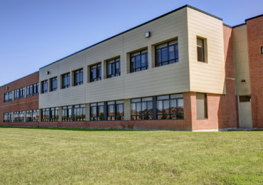 Exterior of generic school building, sunny summer day.